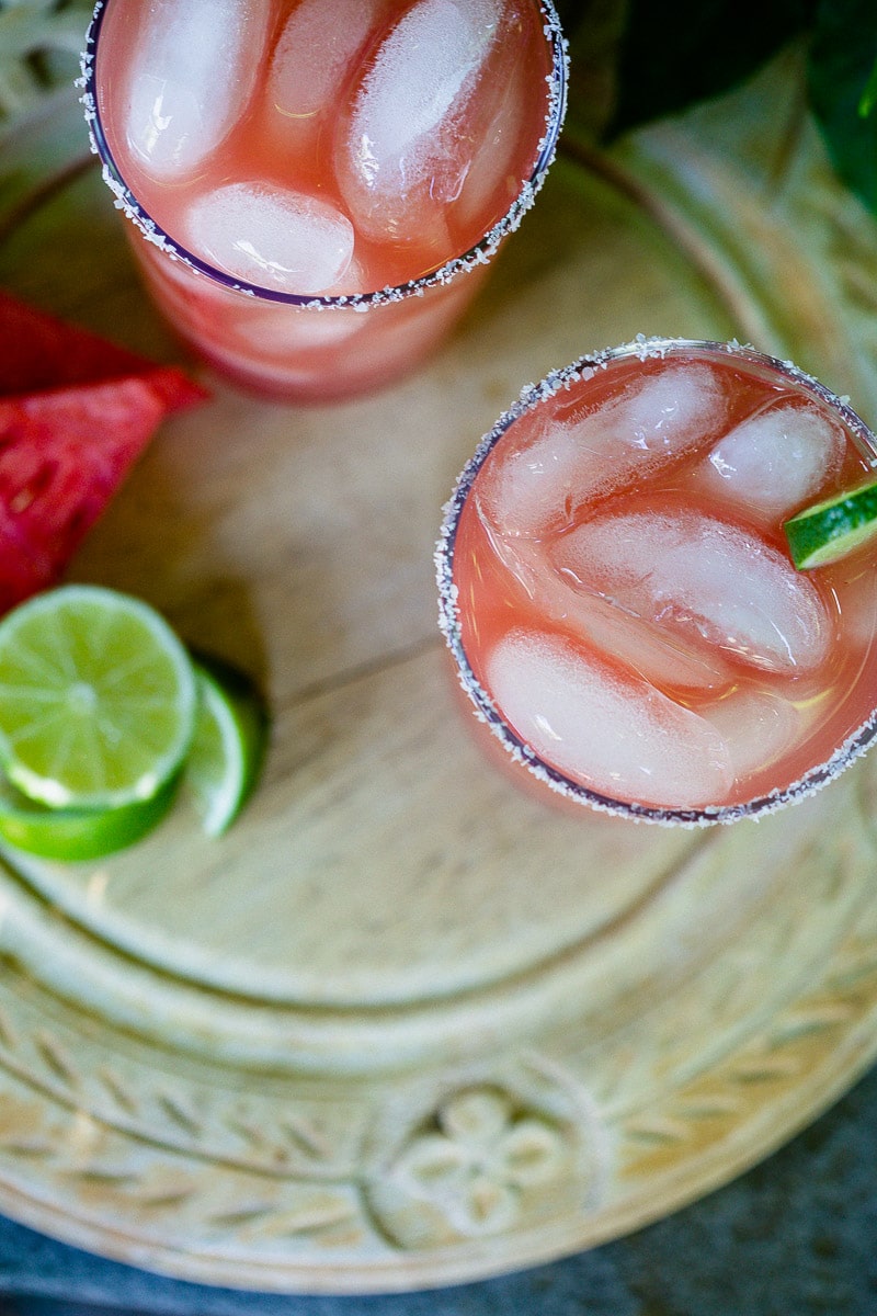 Watermelon Margaritas (Paleo & Refined Sugar-Free) served in glass tumblers full of ice and garnished with a lime next pieces of fresh watermelon and slices of lime