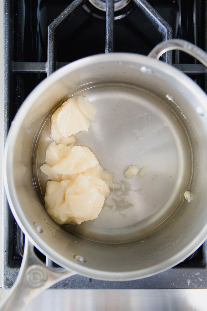 raw honey with water in a pot over the stove