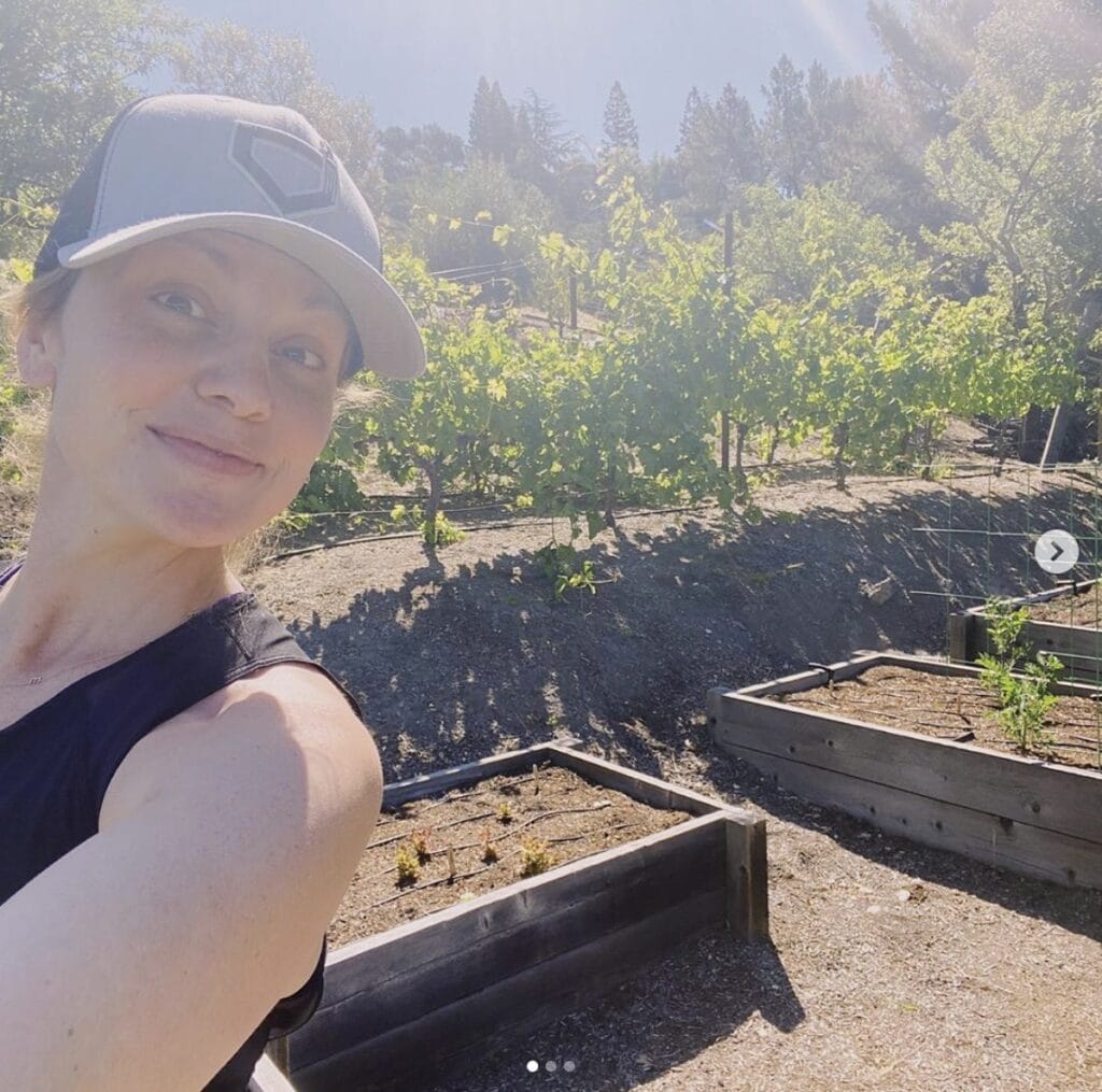 Woman takes a self picture showing off her raised garden boxes 