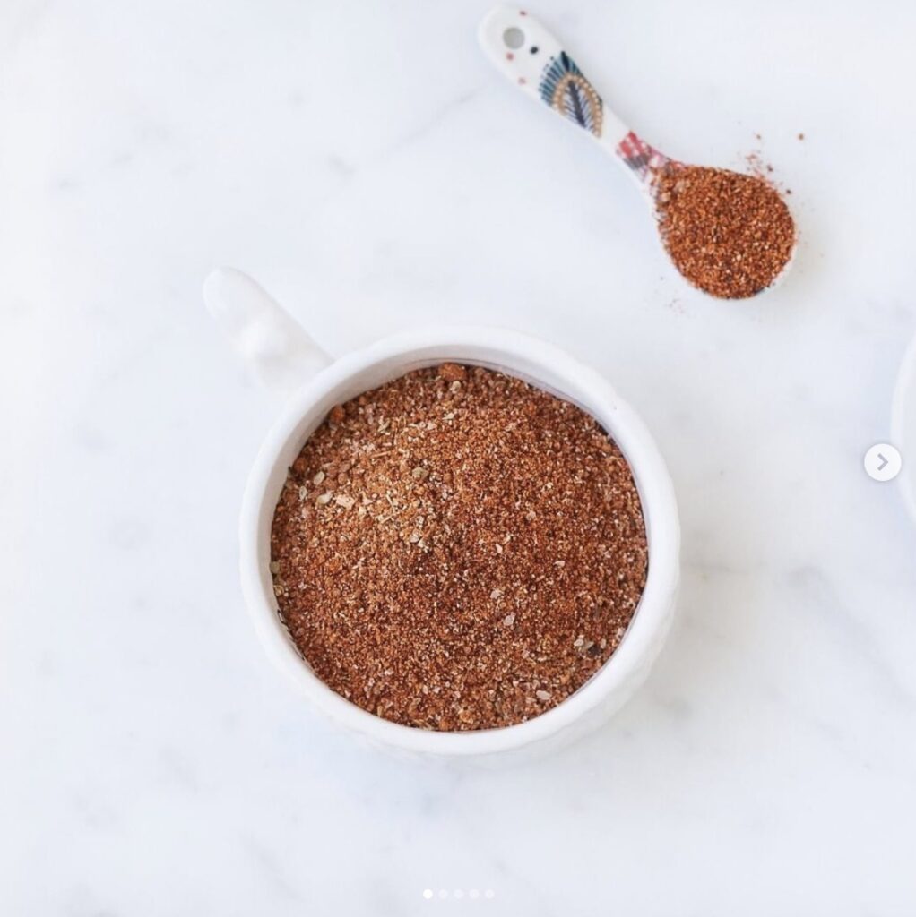 barbecue dry rub seasoning in a white container on a white marble counter