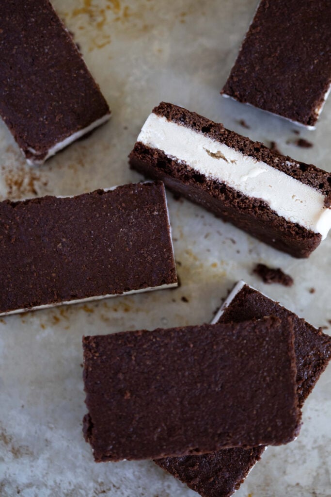 Ice cream sandwiches in different positions laying on a counter 