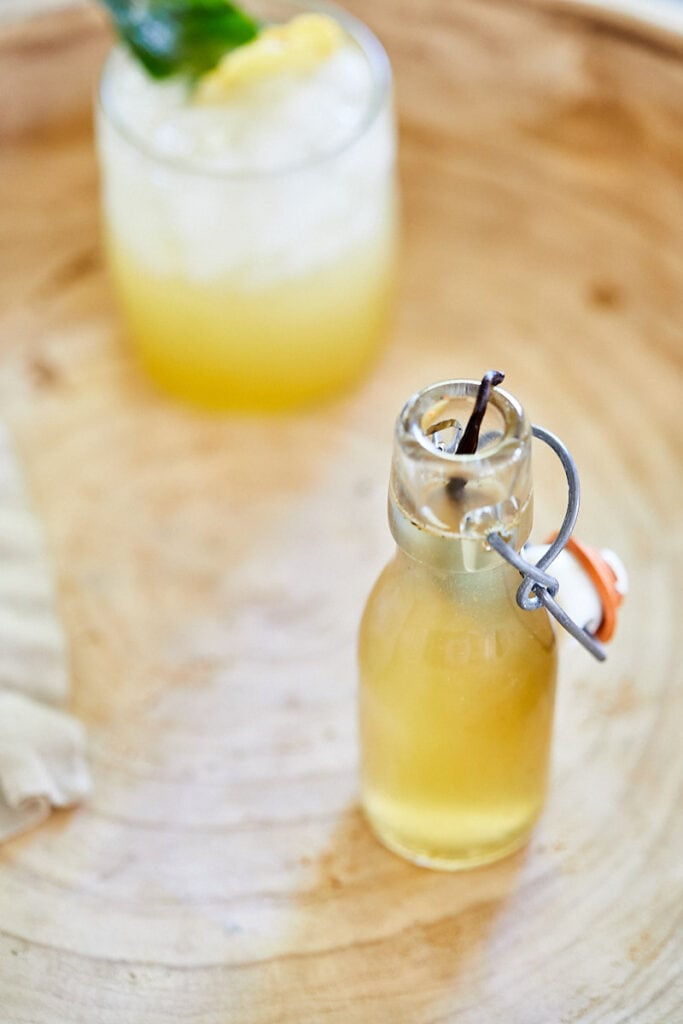 Vanilla Honey Simple Syrup in a glass bottle with a bit of vanilla bean in it. 