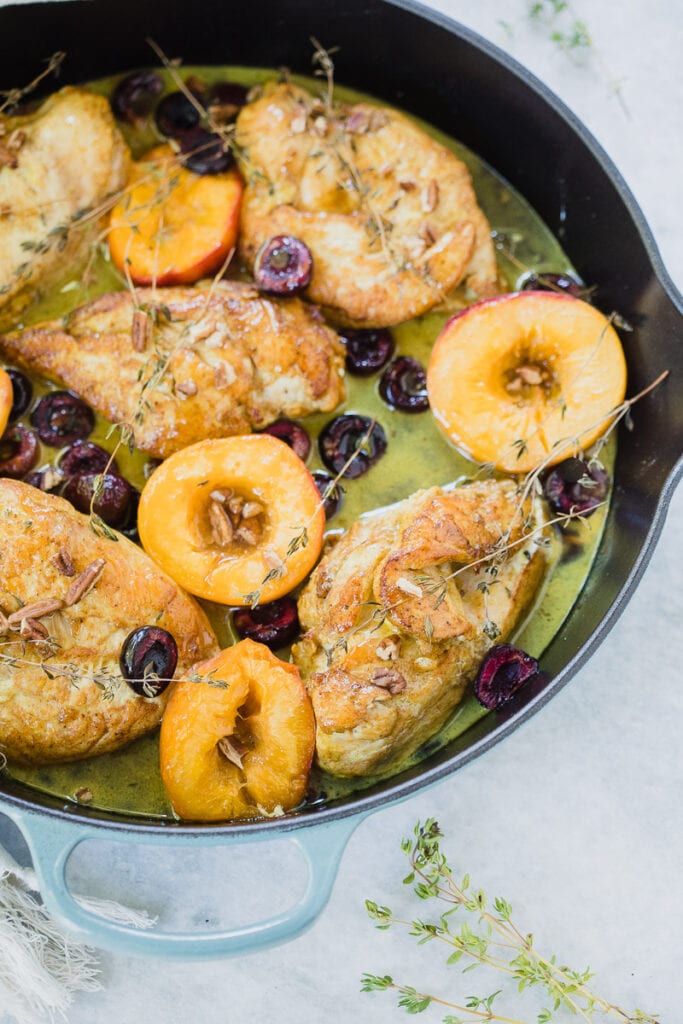 Spiced Roasted Chicken served in a skillet with a peaches and cherries 