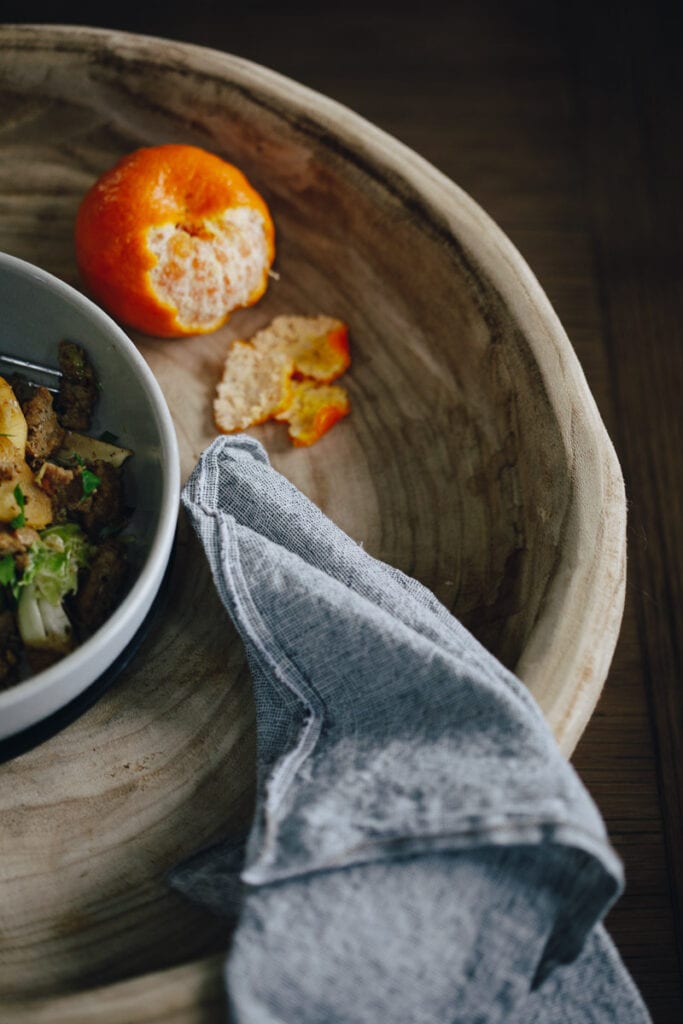 half peeled clementine and egg free paleo breakfast bowl with a cloth napkin nearby 